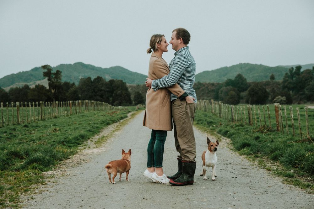 engaged couple and their dogs together on the family farm on the west coast