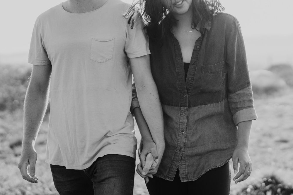 close up of couples chests walking towards camera holding hands