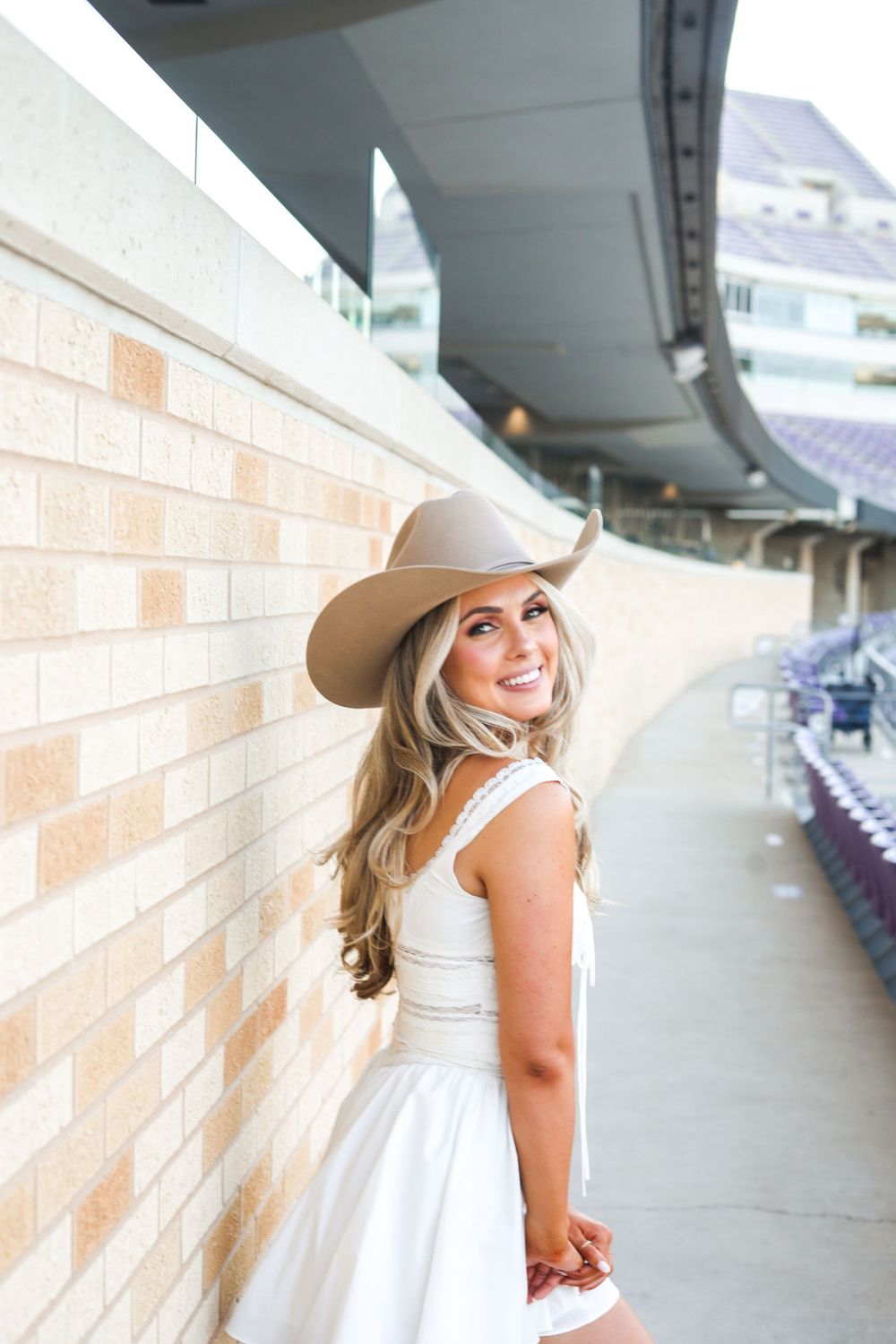Fashion portraits captured in a modern stadium concourse with dramatic lighting and architectural elements.