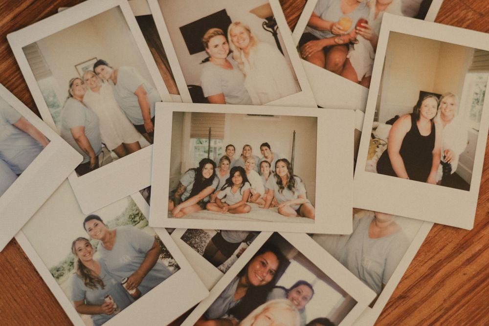 Collection of polaroid photos spread out on wooden surface capturing wedding day memories.