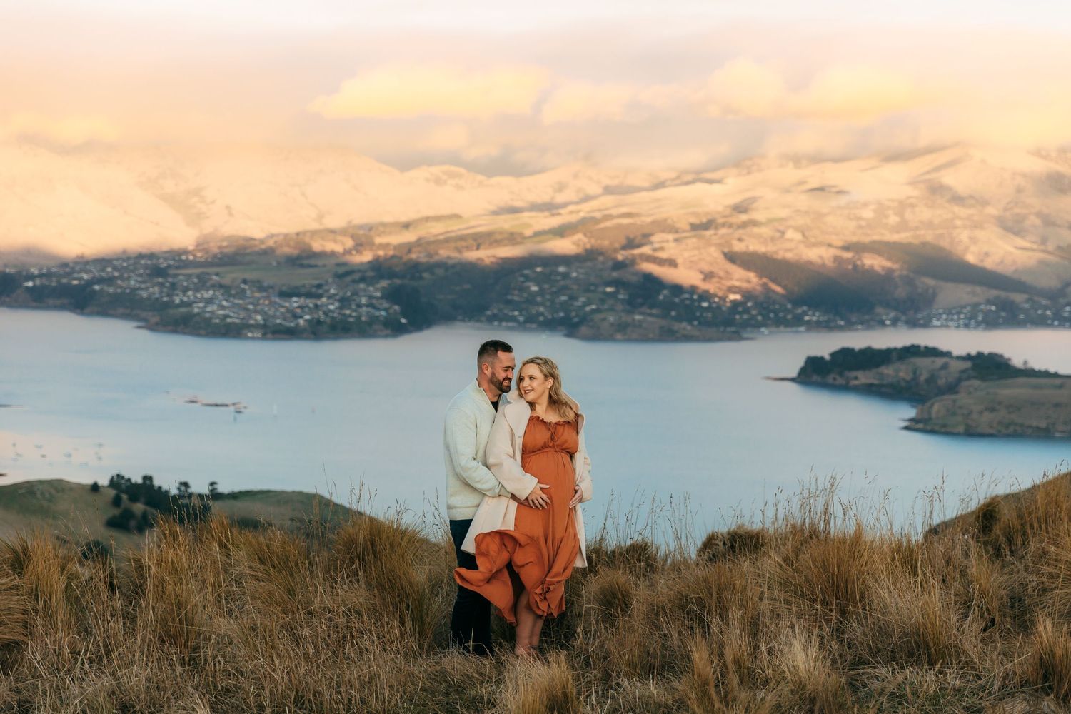 Asian family of 4 with mum and dad kissing, their daugter cuddling dad, and their son blocking his ears. Halswell Quarry, Christchurch.