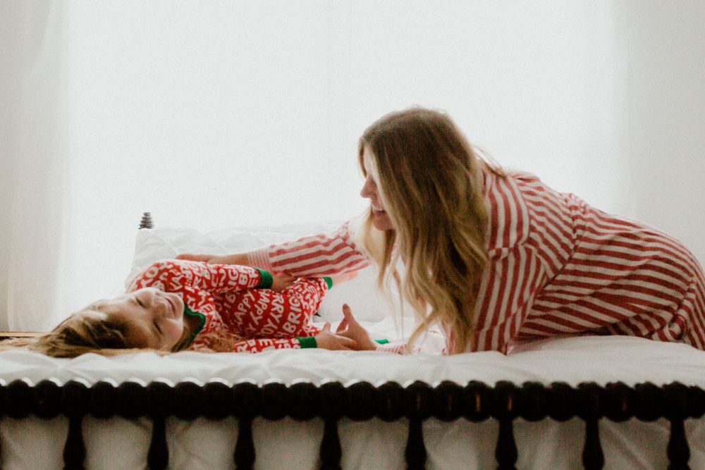 Sweet candid moment of bonding captured on a white bed.
family photography