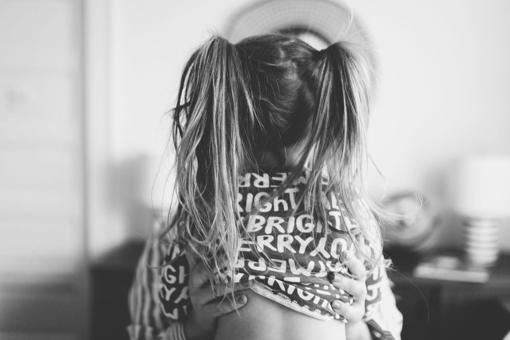 Artistic black and white portrait showing text on clothing from behind.