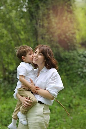 Sweet moment shared between parent and child outdoors in a natural garden setting.