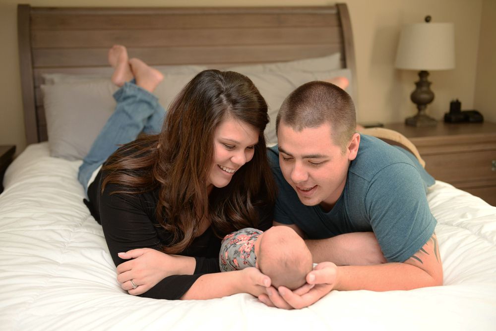 Family members sharing an intimate moment on a bed.