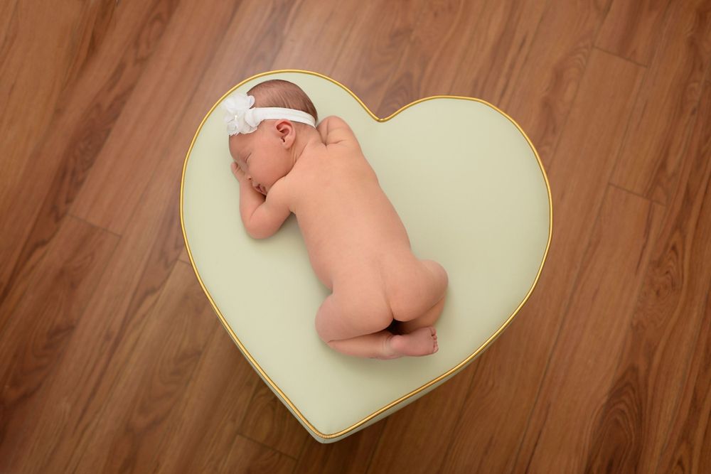 Heart-shaped cushion on wooden floor with soft lighting.