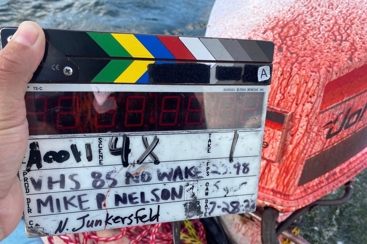 Film slate for scene 148 being held up against a red background.
