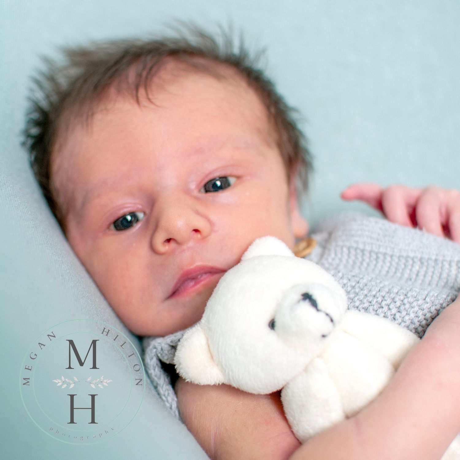 Close up of newborn boy holding teddy bear