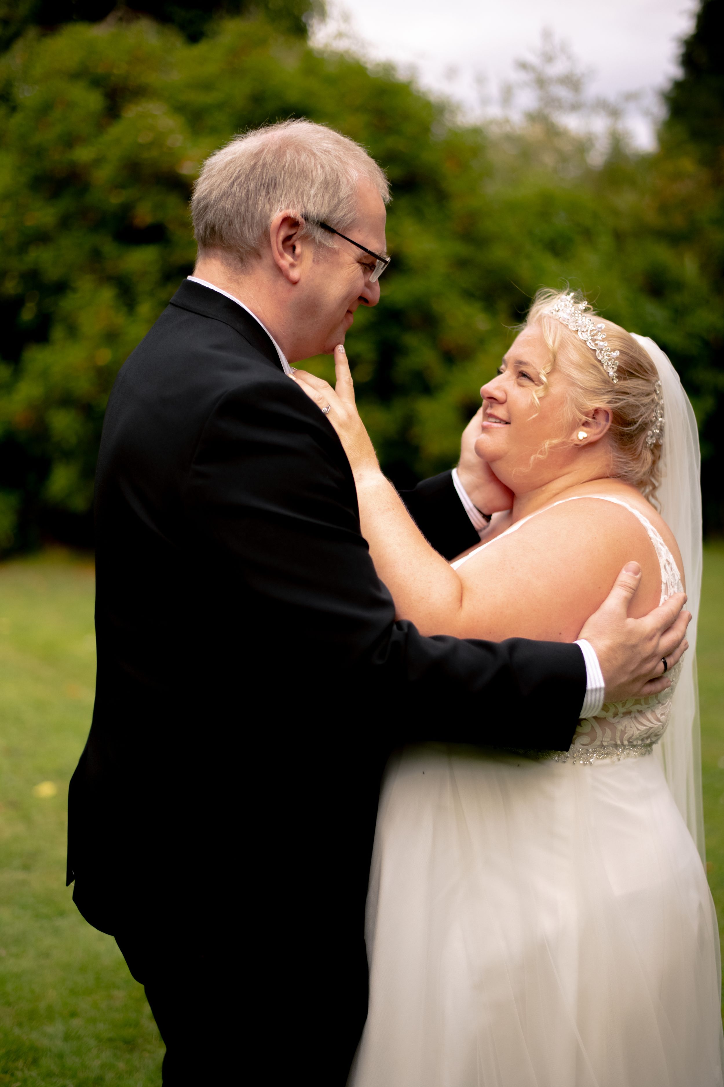 A joyful moment captured between newlyweds sharing a loving embrace outdoors.