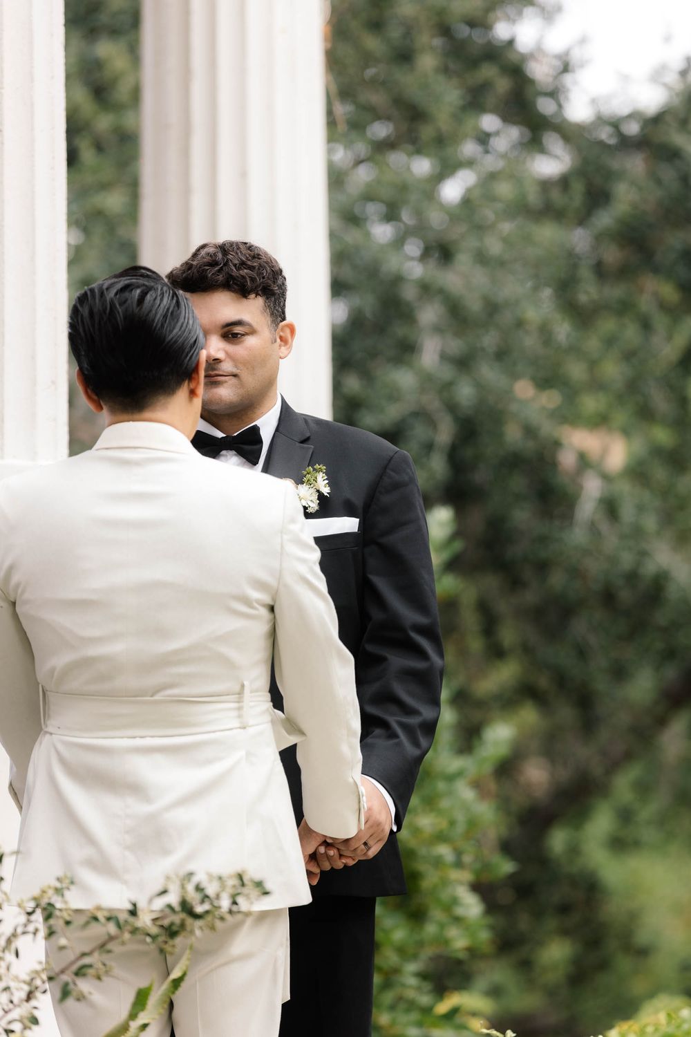 Intimate wedding moment captured between two people in contrasting black and white formal attire.