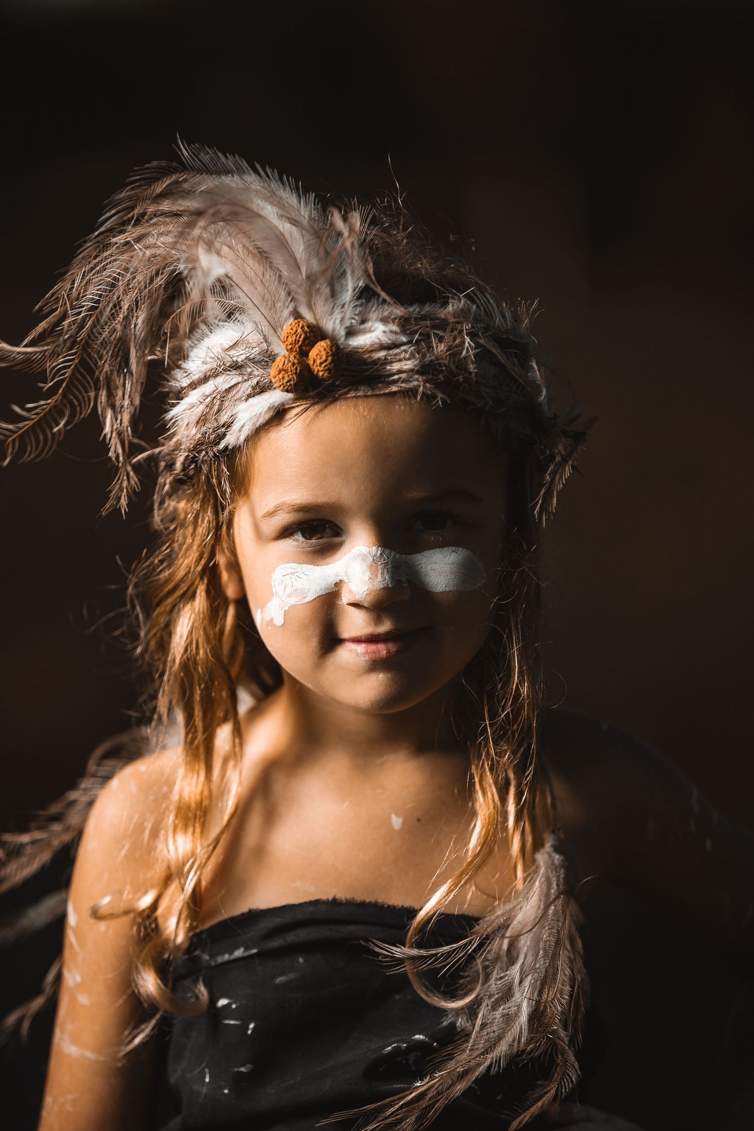 Series of dramatic portraits showing tribal-inspired face paint and styling.