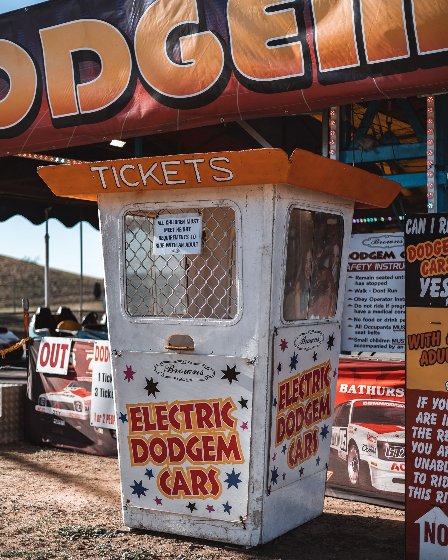 Vintage dodgem car ticket booth with retro signage and advertisements.