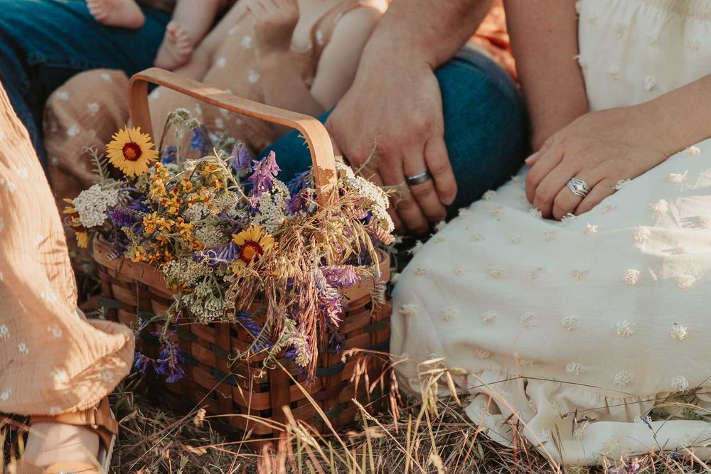 close up of spokane wild flowers in a basket with wedding rings in background