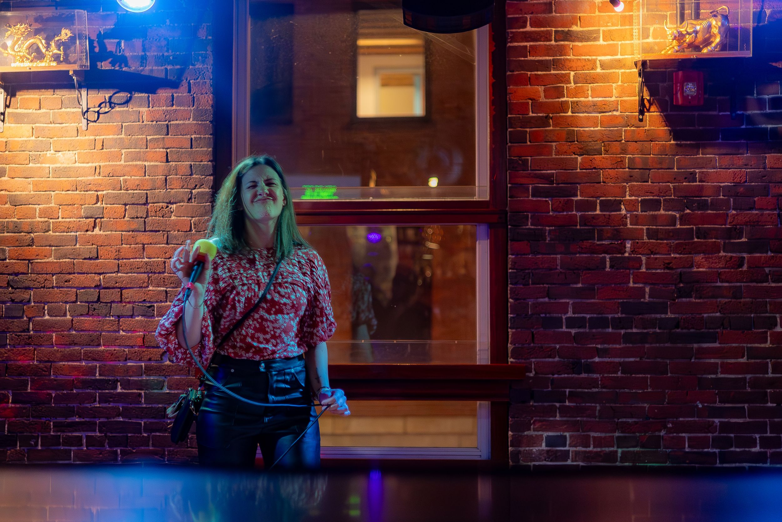 Atmospheric nightclub scene with brick walls illuminated by colorful lights.