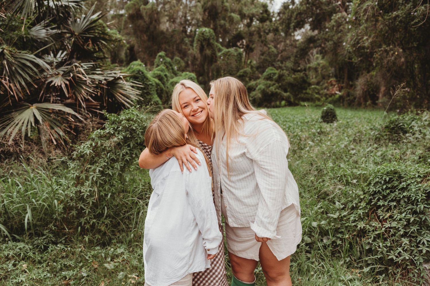 Daughters kissing mother on cheek at Naru Beach, Swansea during Lake Macquarie family photoshoot