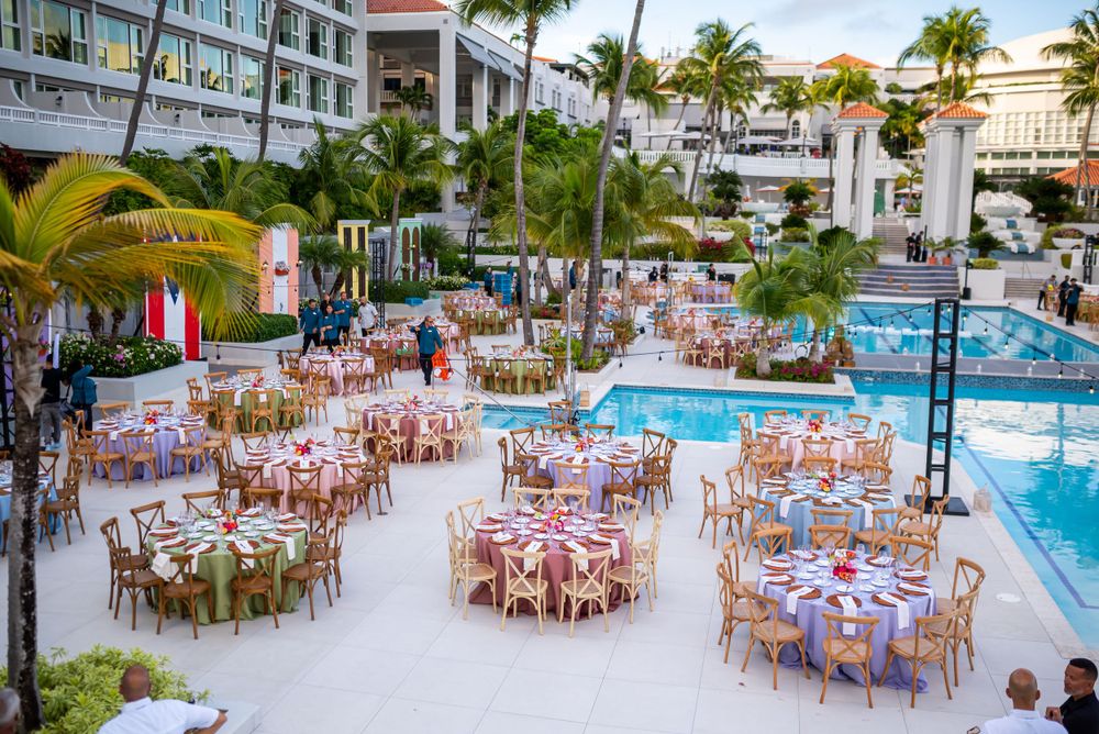Pool deck transformed into an elegant dining venue with tables and chairs set for a special event.