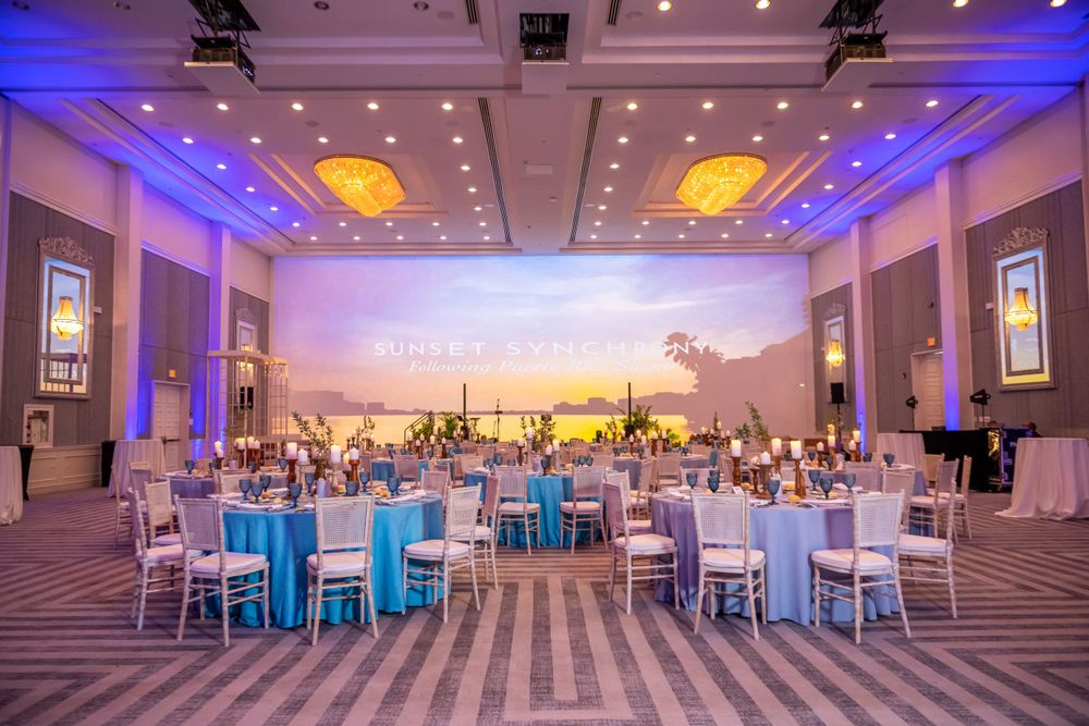 Elegant ballroom setup with blue and white decor and dramatic lighting for a formal event.