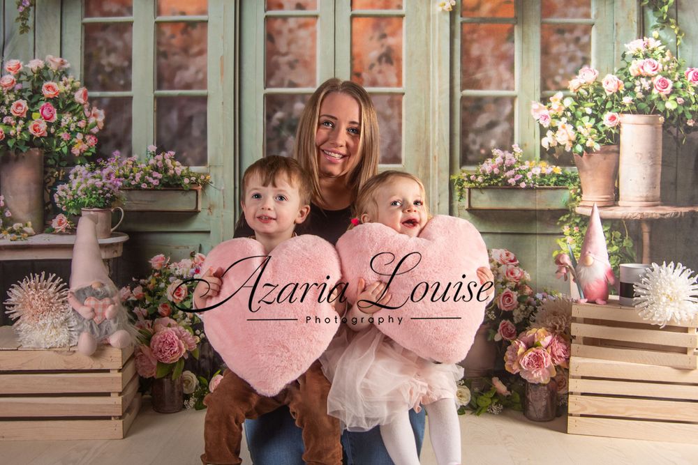 Pink floral spring photography setup with vintage windows and heart decorations.