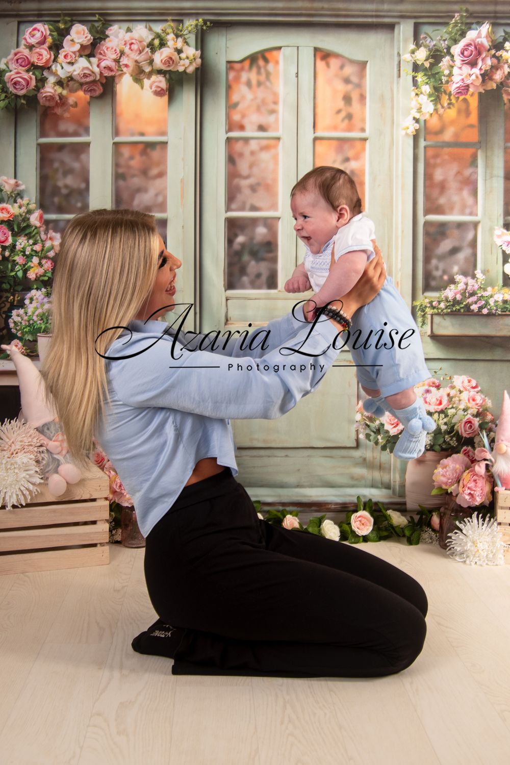 Professional photo setup against vintage door with pink roses and floral accents.