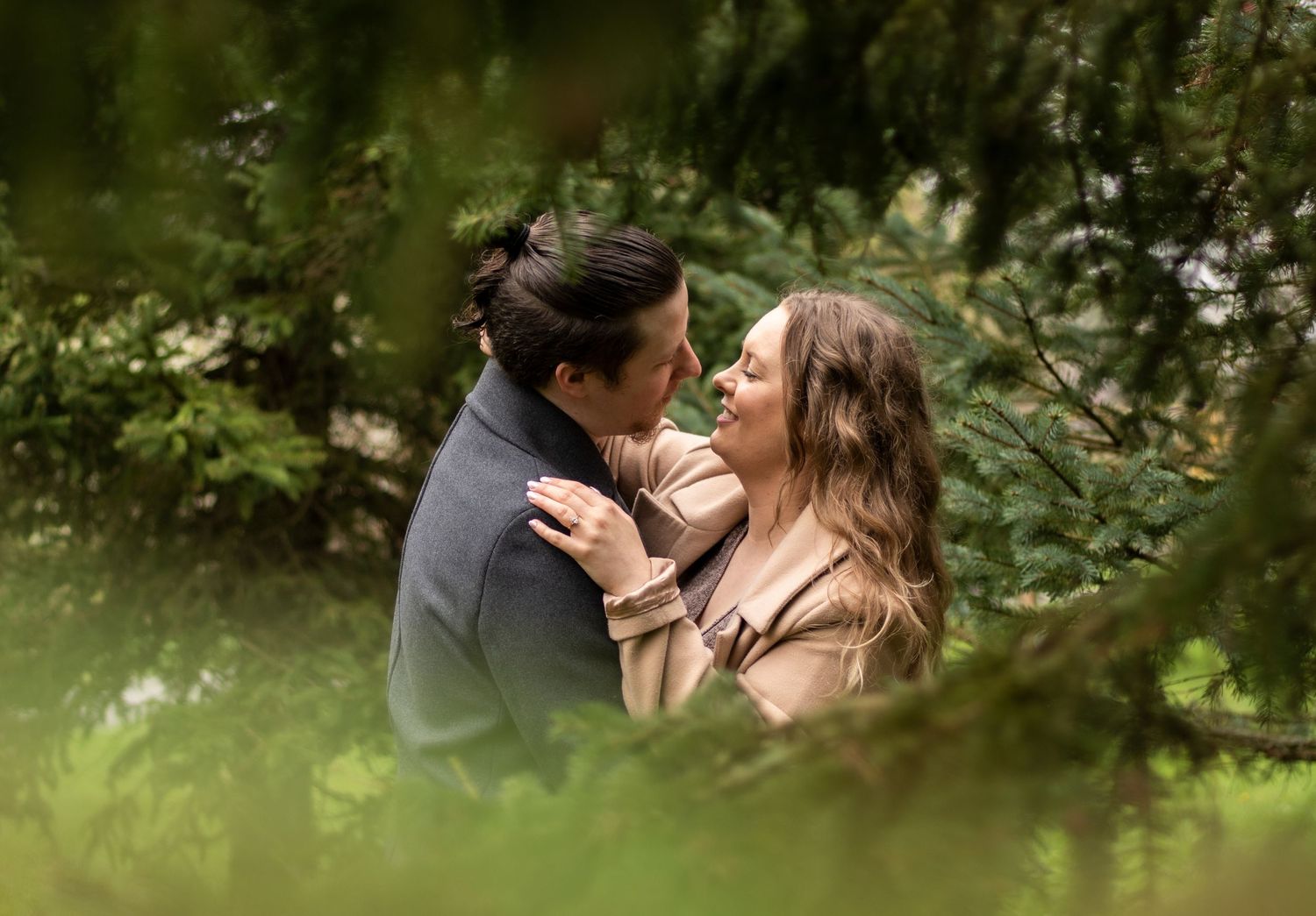 Engaged couple through the trees