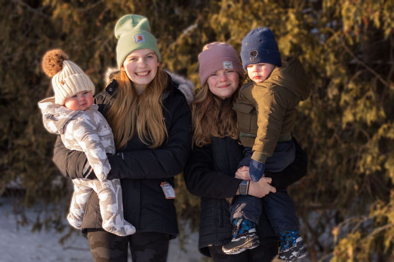 Four siblings in the winter sun in a forest