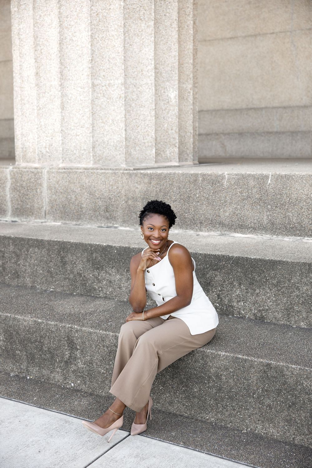 Four connected photos show someone in a white tank top and khaki pants posing casually on concrete steps with columns.