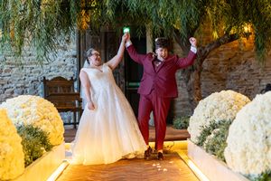 Wedding party celebrates on a rustic stone patio with white floral arrangements. Casual Captures Wedding Photography