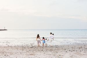 A series of serene beach scenes with people walking along the shoreline at sunset.