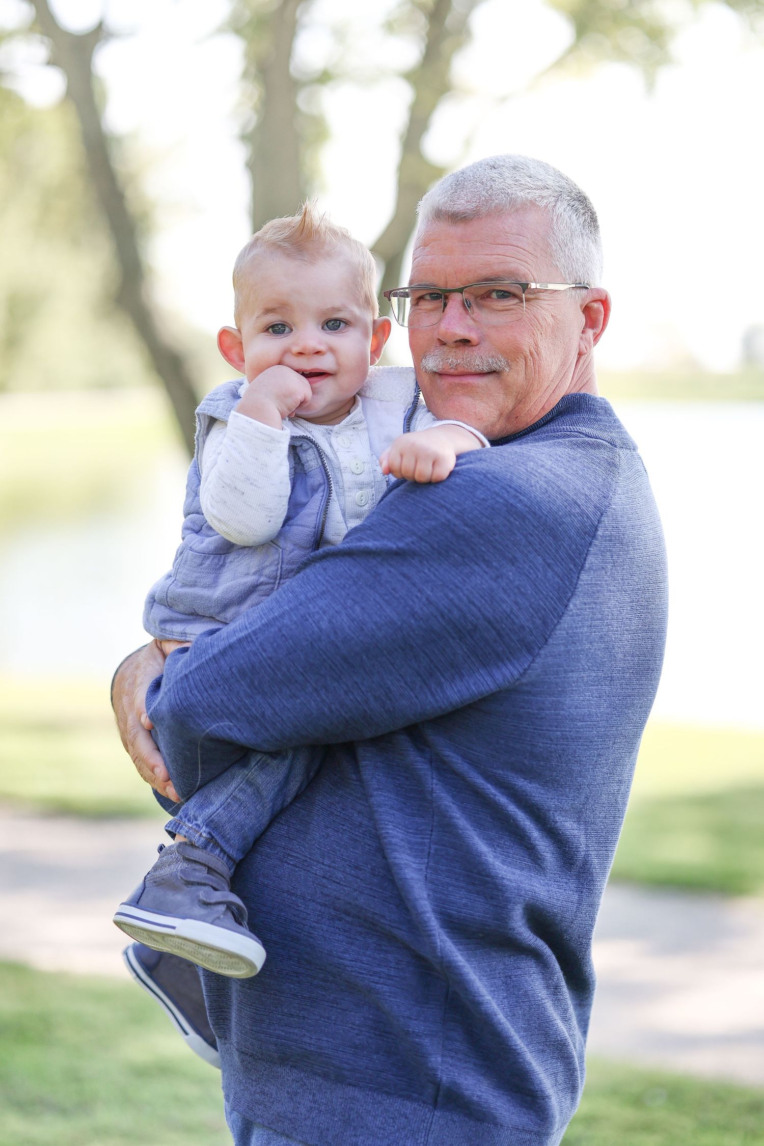 Sweet candid moment between adult and baby during outdoor photo session.