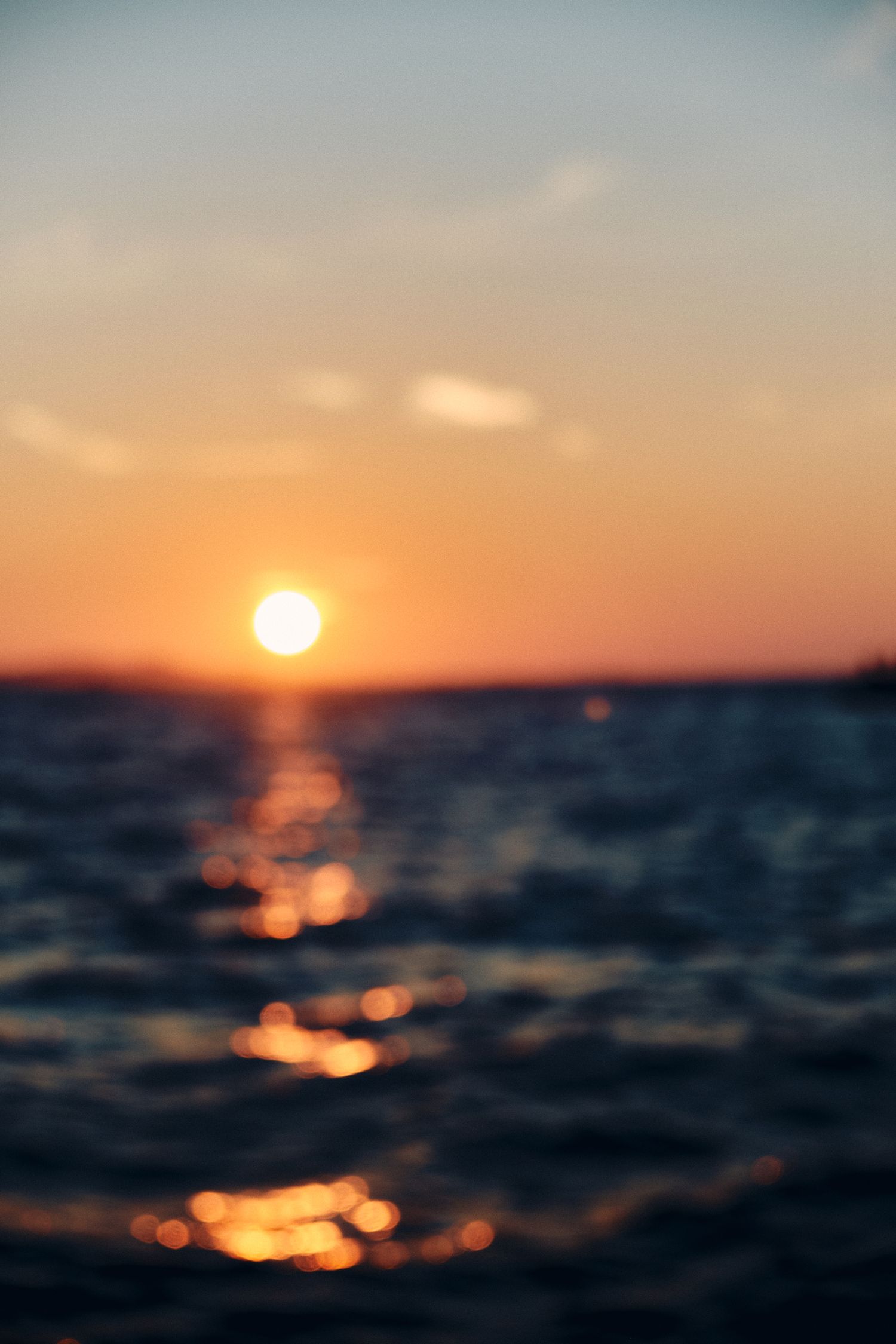 Stunning sunset over ocean waters creating golden reflections on waves.