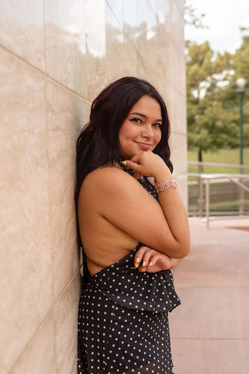 girl posing for a photo in front of an exterior wall