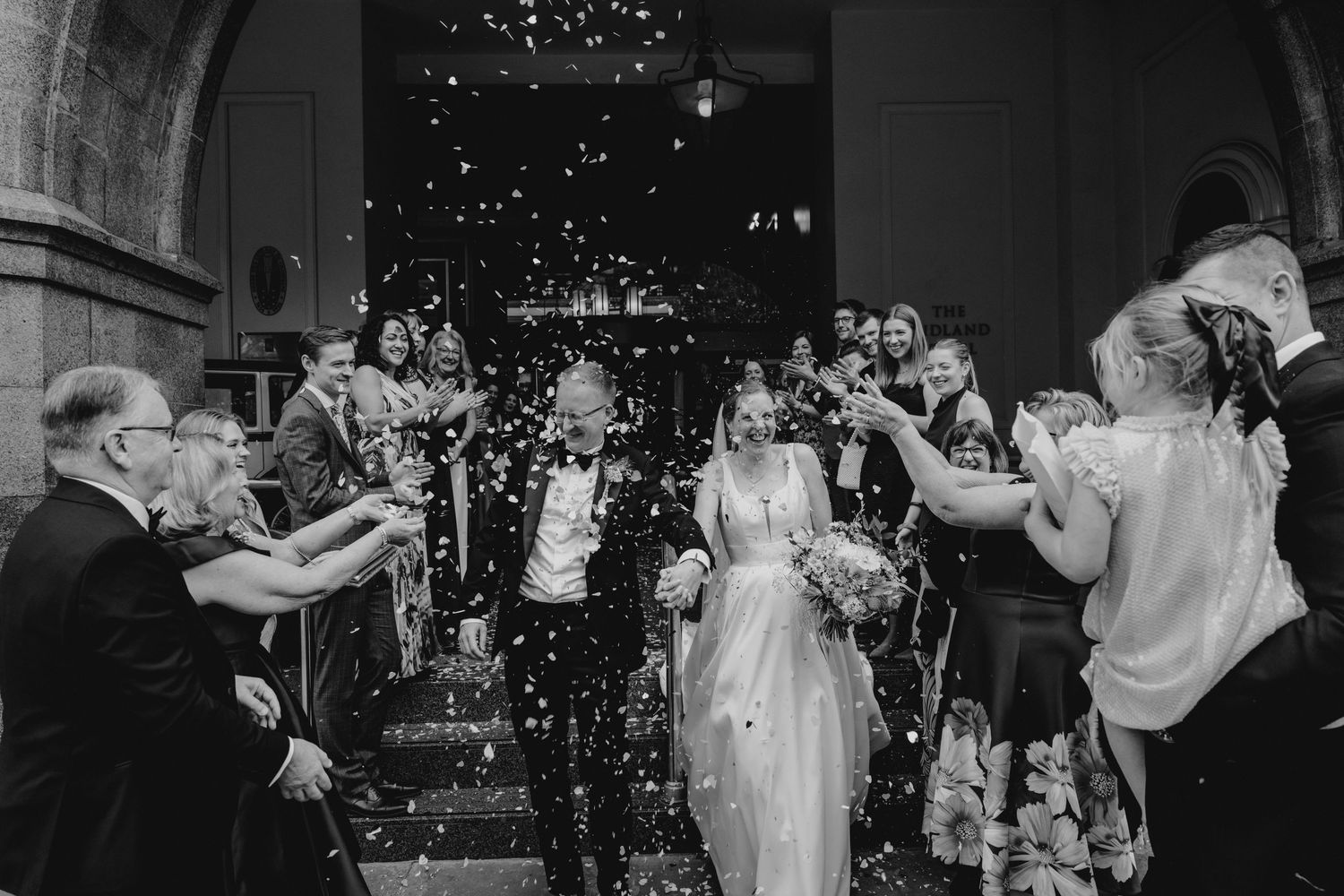 Black and white photo of a romantic moment under a flowing veil.