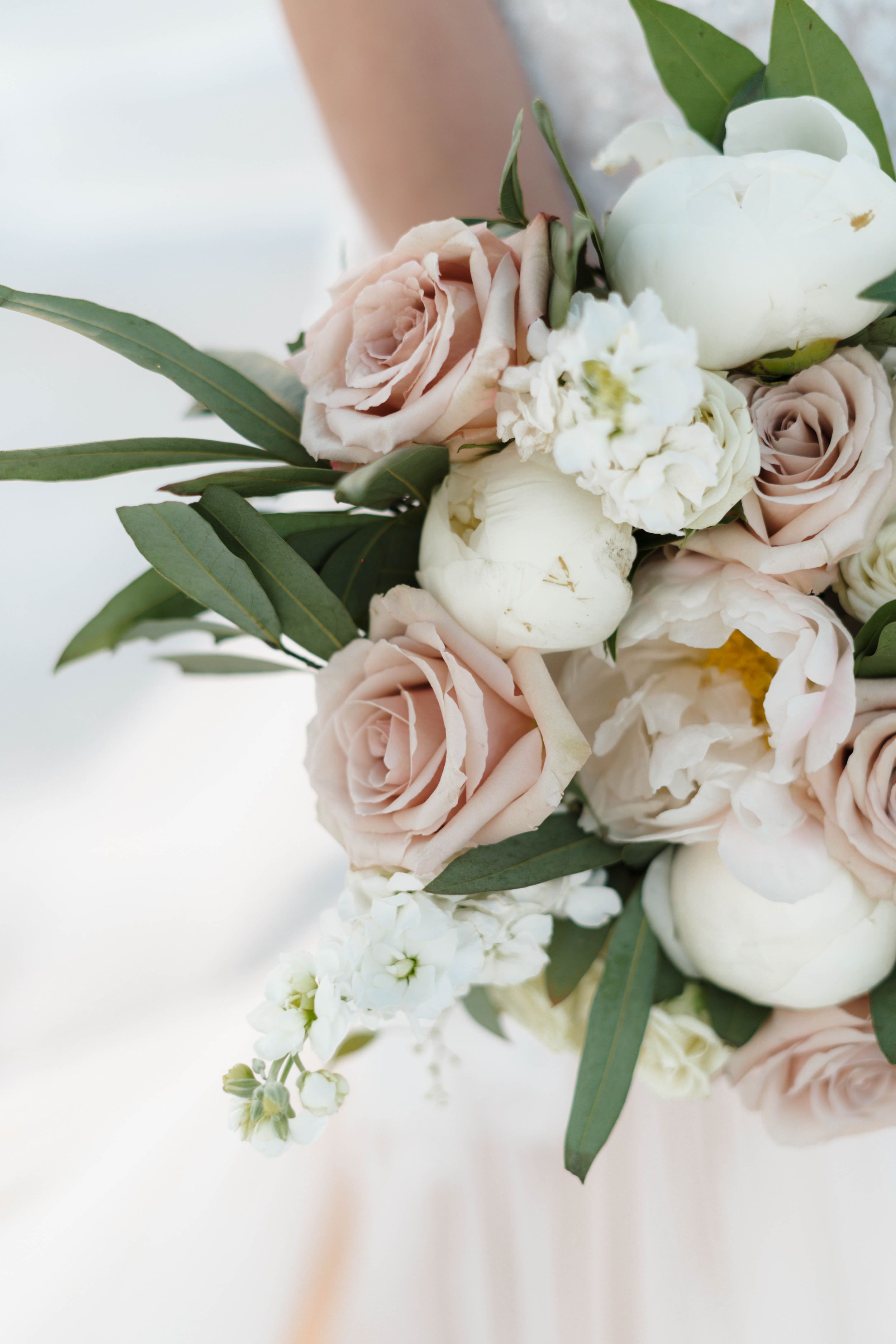 Elegant bridal bouquet with blush roses, white peonies and eucalyptus leaves.
