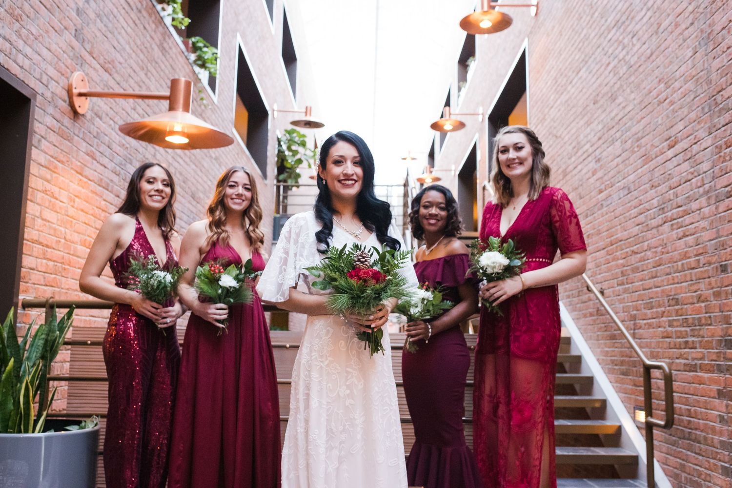 bride and bridesmaids with brick background wedding day