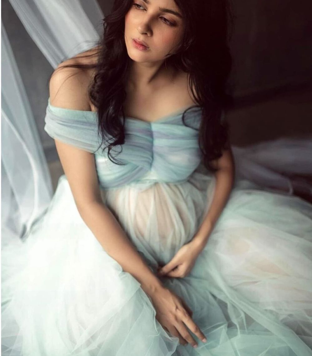 Romantic off-shoulder powder blue tulle dress captured in delicate boudoir setting.
