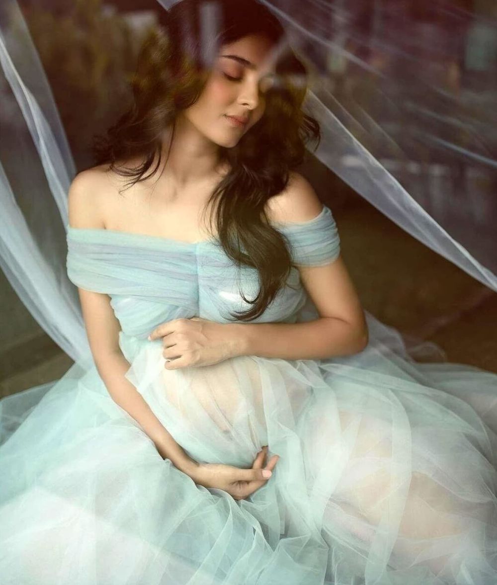 Dreamy portrait in powder blue off-shoulder tulle gown with flowing veil.