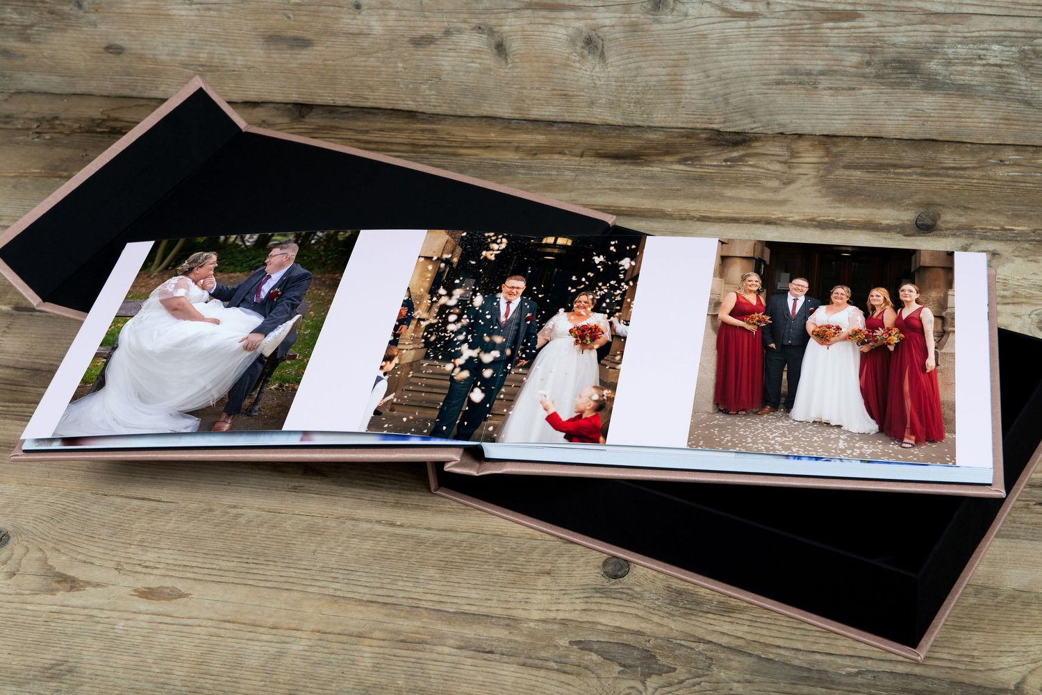Wedding photo album displaying multiple ceremony and group photos on wooden surface.