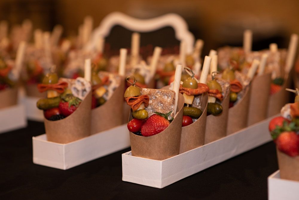 Rows of appetizers and hors d'oeuvres presented in elegant serving containers.