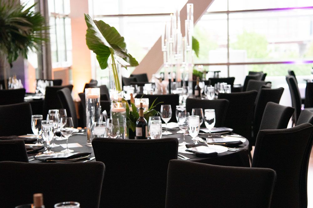 Modern restaurant interior with black chairs and tables set for fine dining.