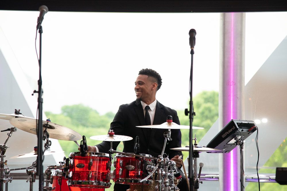 Live band performing with drums and musical equipment on stage.