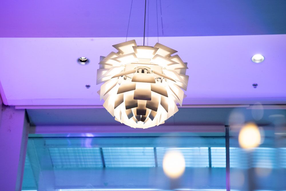 Modern venue space with purple uplighting and contemporary ceiling fixtures.