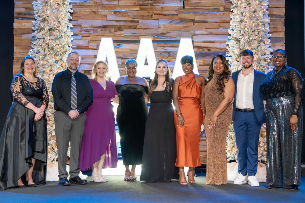 A group photo of people dressed in formal attire at an evening event.