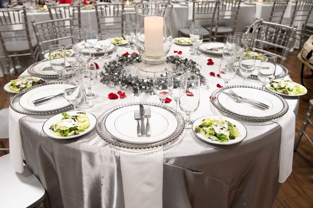Round banquet tables with silver chiavari chairs set for an elegant wedding reception.