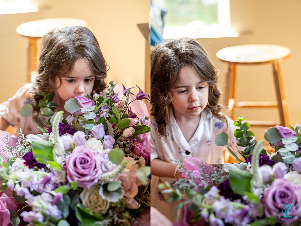 Child examining purple and pink floral arrangements in natural window light.