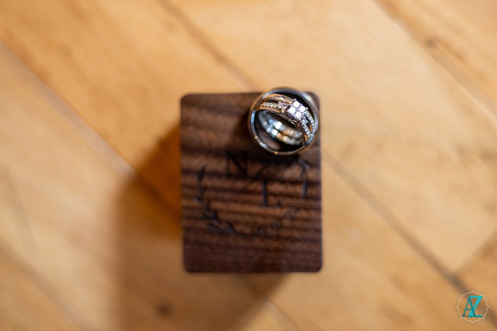 Wedding rings displayed on a dark wooden surface with text.