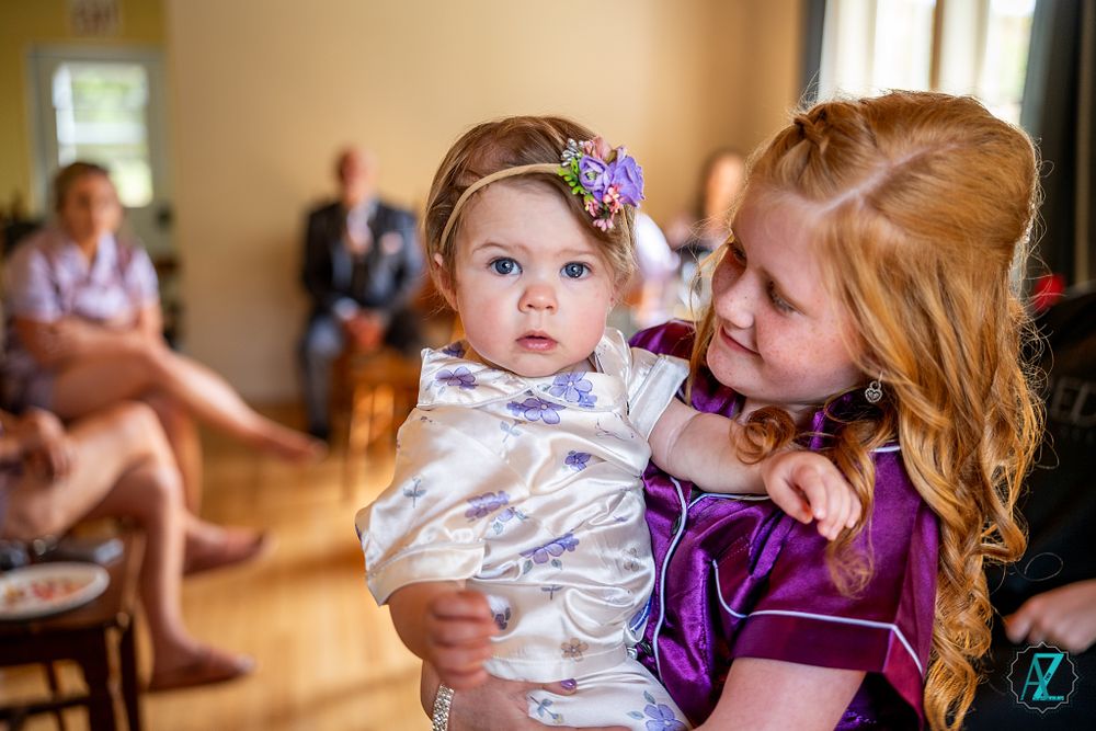 Two people in formal attire share a tender moment during wedding preparations.