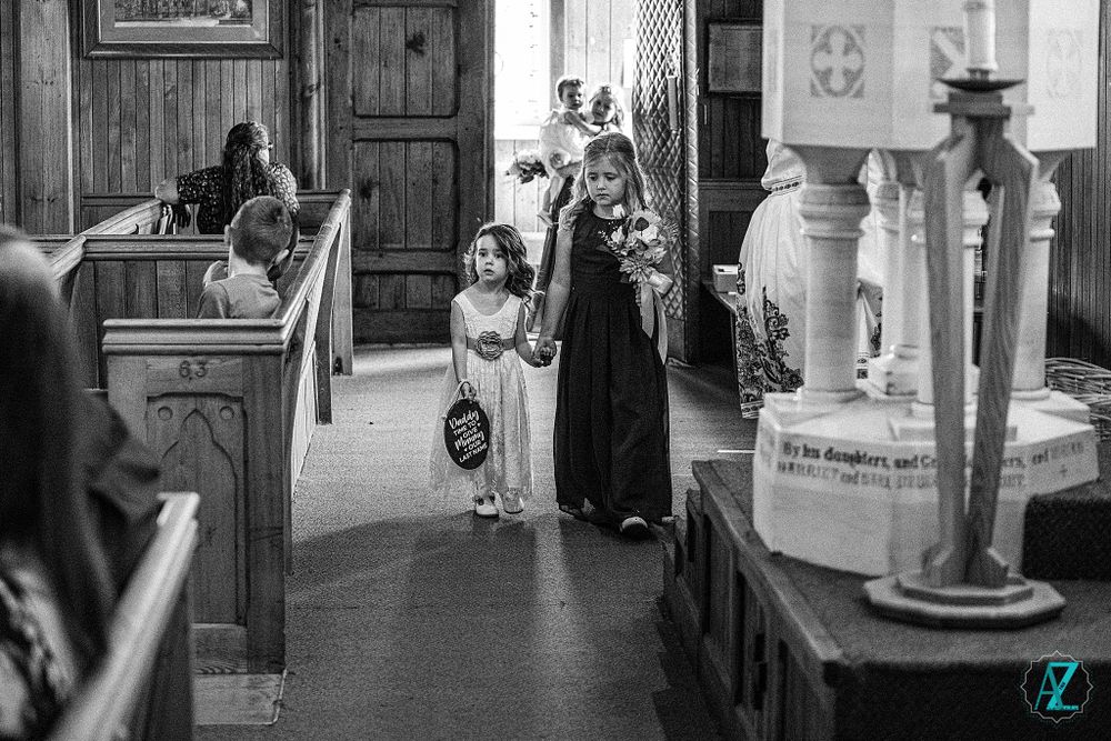 Black and white photo of a church ceremony procession walking down the aisle.