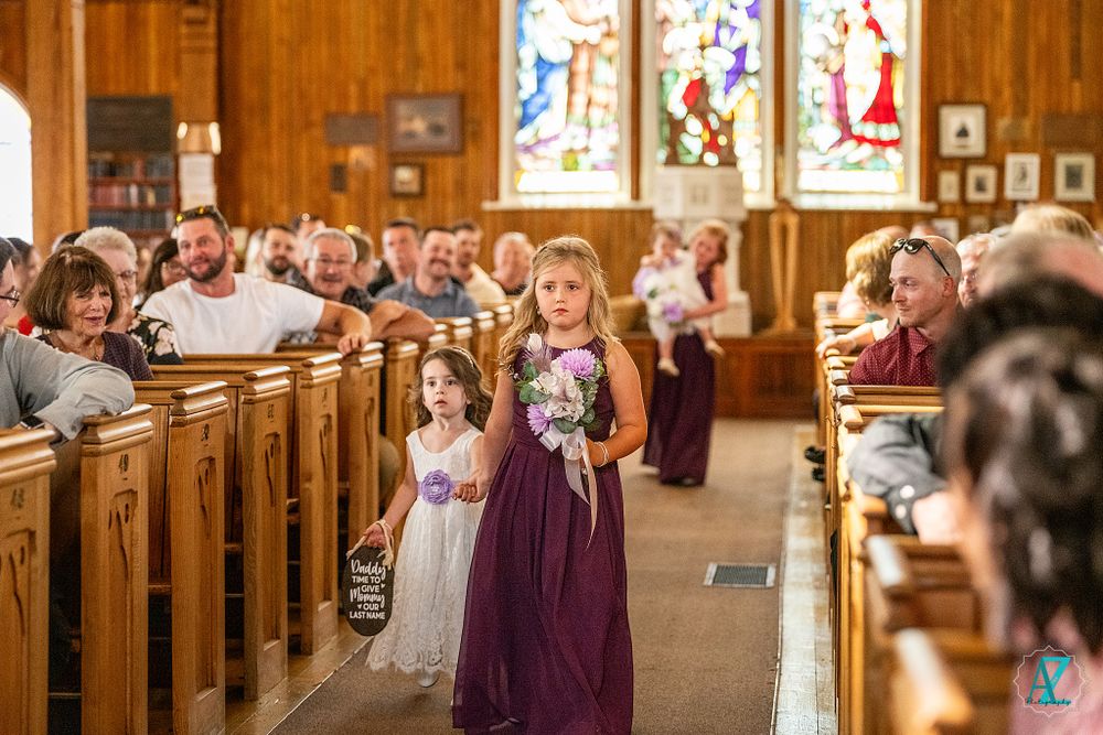Wedding ceremony in traditional church with colorful stained glass windows and wooden interior.