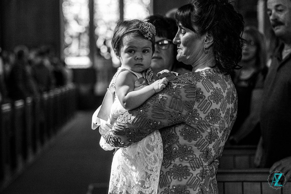 A candid black and white moment captured during a church wedding ceremony.