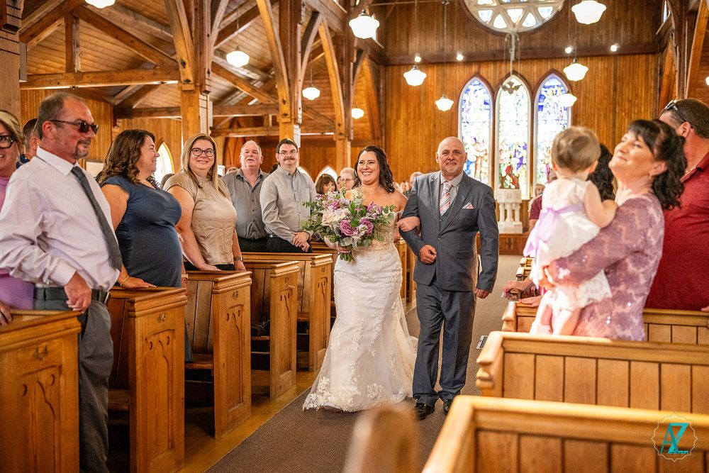 Wedding ceremony in a wooden church with gothic arches and stained glass windows.